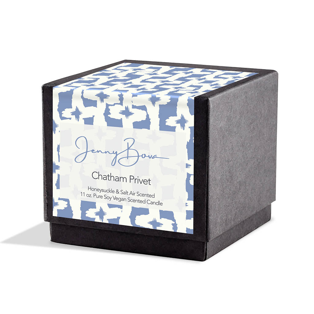 Square black candle box with a label covering front and top. The label is a blue and white geometric design. On the front are the Jenny Bova logo, the name of the candle, "Chatham Privet,” and product details. The background is white.