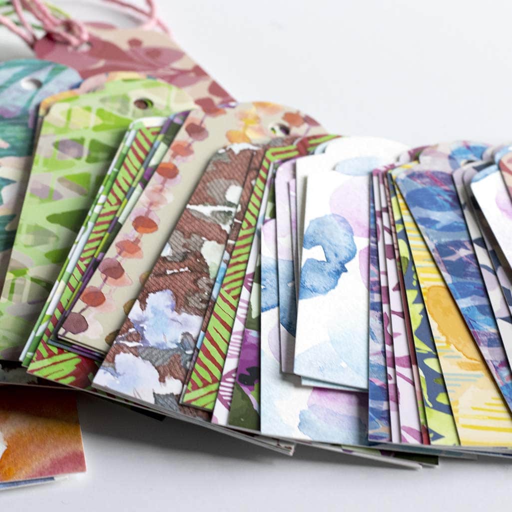 Close up photo of a stack of Jenny Bova&#39;s patterned gift tags and original watercolor gift tags. 