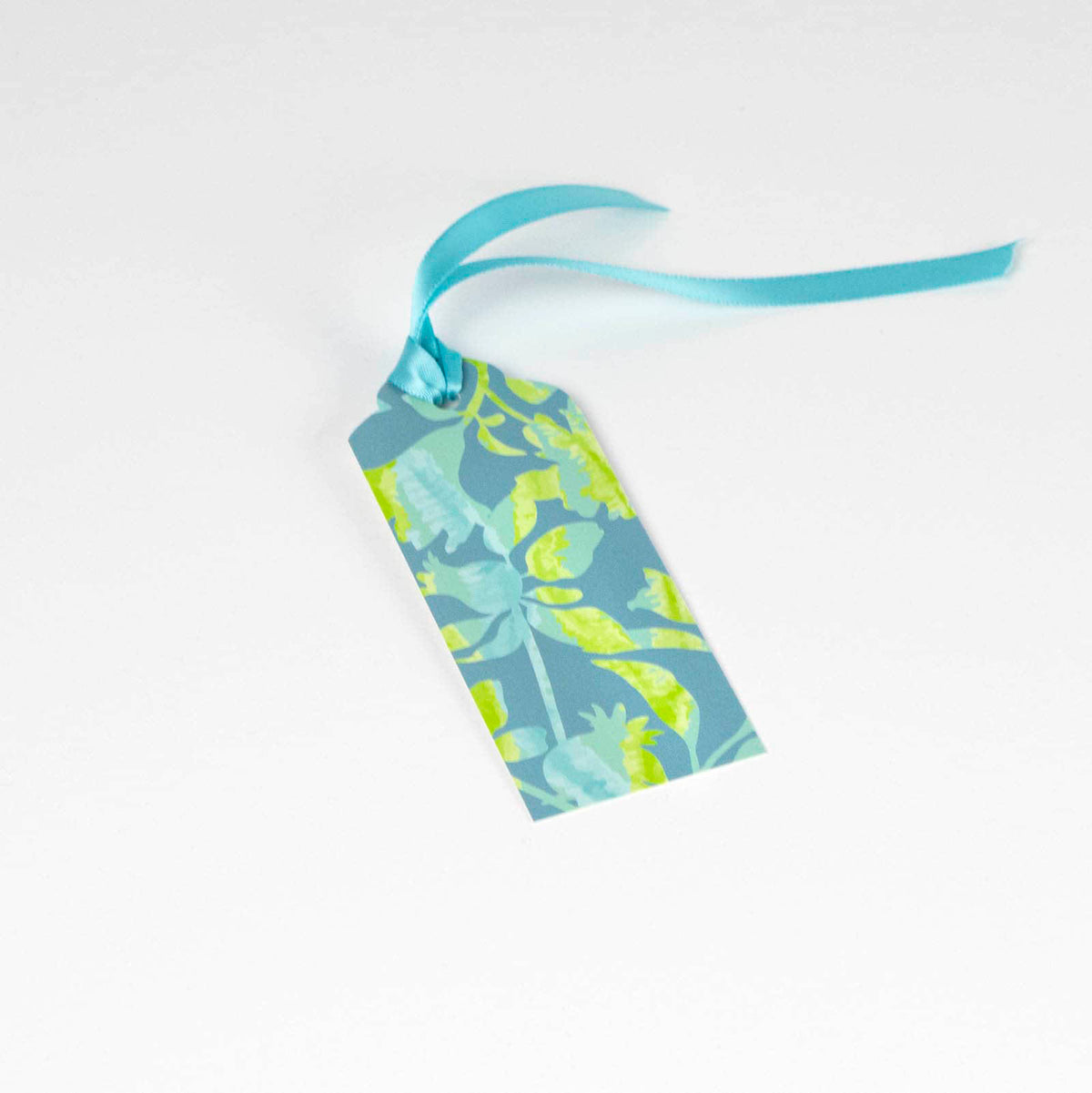 Single gift tag with beautiful patterned floral design in blue and green with matching aqua ribbon attached