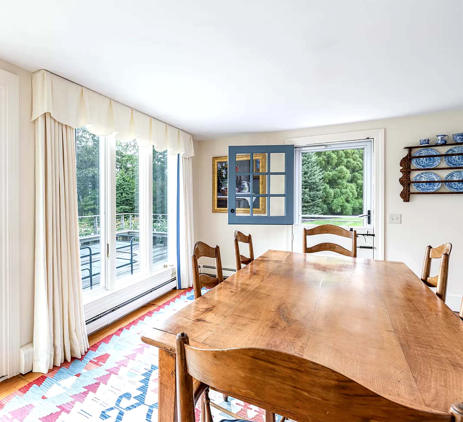 Costal dining room with antique table and tabriz rug