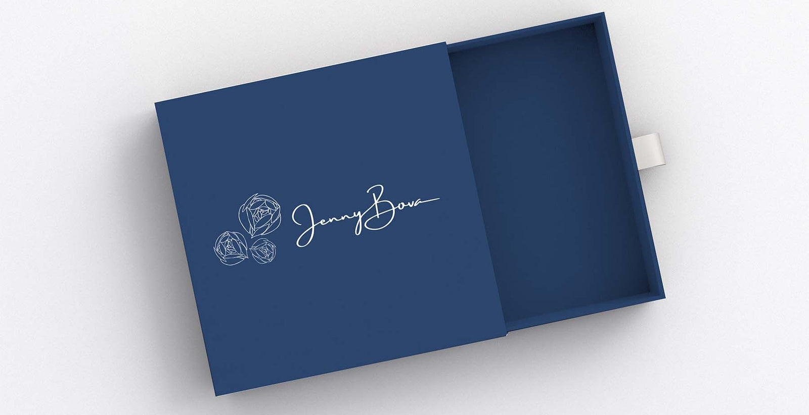 gift box in dark blue with ribbon to slide open. Jenny Bova logotype and flowers shown on top in white