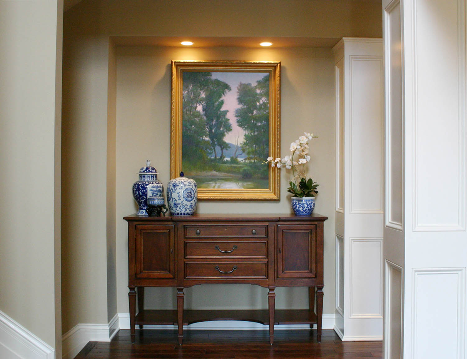 Entry table with blue and white pottery and a landscape painting