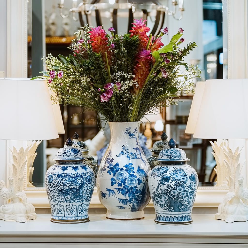 blue and white canton vases and urns in front of a mirror with white lamps