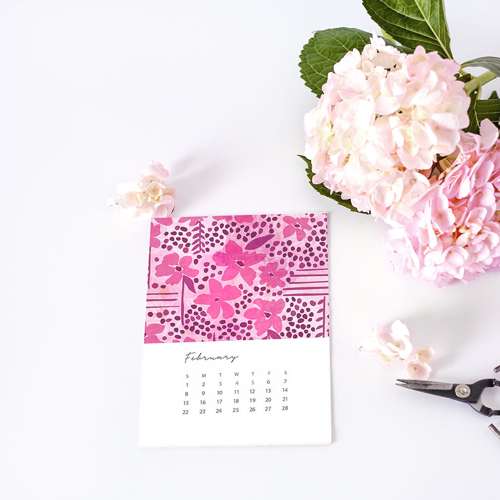 Floral-patterned calendar with pink flowers and green leaves on a white background
