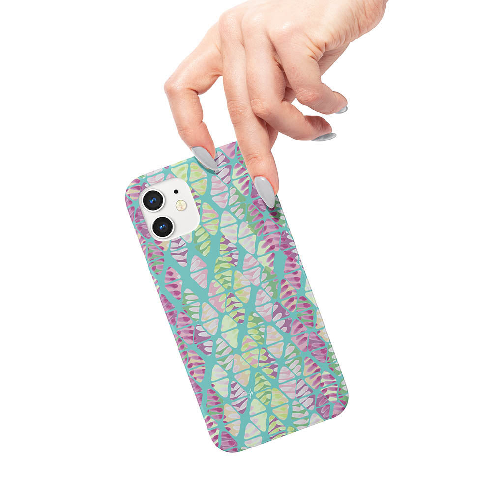 Watercolor triangle and chevron pattern in teal, greens, and purples on an iPhone case in a woman&#39;s hand