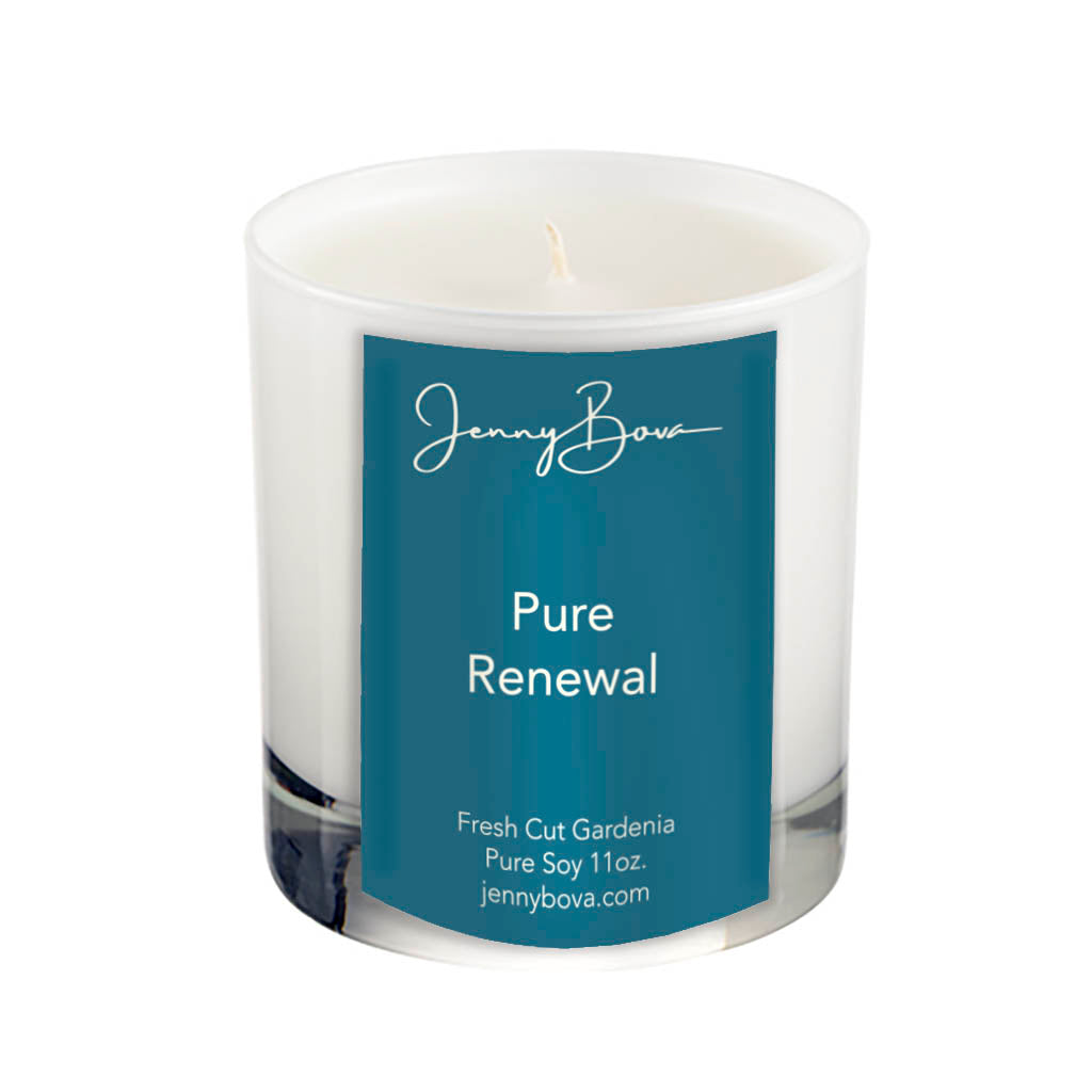 11 oz soy candle in a white glass jar with white wax. On the front of the jar is a deep aqua label with the Jenny Bova logo, the name of the candle, &quot;Pure Renewal&quot;, and product details. The background of the image is white.
