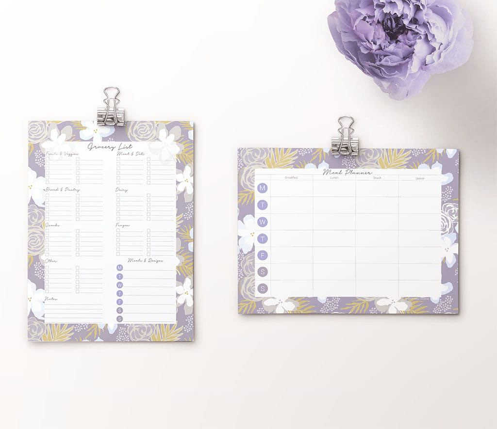Downloadable grocery list and meal planner pages shown on binder clips with purple flower in corner. Pattern around pages is gray blue with white, blue, yellow. 
